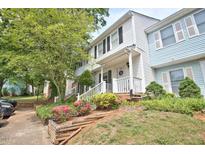 Townhouse exterior showing the covered entrance, colorful landscaping, and a glimpse of the neighboring unit at 10 Grove Park Rd, Durham, NC 27705