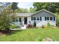 Charming single-story home with black shutters, landscaped front yard, and inviting entrance at 1004 Greenwich St, Raleigh, NC 27610