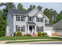 Charming two-story home featuring gray siding, black shutters, well-manicured lawn, and attached garage at 101 Worsham Dr, Chapel Hill, NC 27516