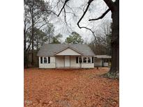 Exterior view of a quaint single-story home with a covered porch and mature trees at 107 E Underwood Ave, Smithfield, NC 27577