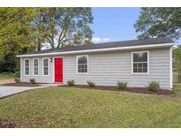 Charming one-story home with gray siding, a bright red front door, and well-manicured landscaping at 1100 Pecan Pl, Durham, NC 27704