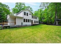 Expansive backyard featuring lush green lawn, mature trees, and a modern two-story home with white siding at 112 Meadowbrook Dr, Chapel Hill, NC 27514