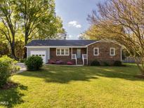 Charming brick home features a well-maintained lawn and a tidy garden with a welcoming entrance at 2581 Green Valley Blvd, Burlington, NC 27217
