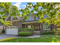 Charming two-story home with stone and brick facade, manicured landscaping, and a welcoming double-door entrance at 3824 Laurel Hills Rd, Raleigh, NC 27612
