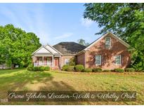 Charming brick home featuring a covered front porch and mature landscaping at 406 N Wakefield St, Zebulon, NC 27597