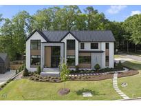 Stunning modern home with manicured lawn, walkway, and lush landscaping at 4139 Rockingham Dr, Raleigh, NC 27609