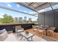Relaxing rooftop deck with city views, stylish seating, and retractable covering perfect for entertaining at 501 S Bloodworth St # 101, Raleigh, NC 27601