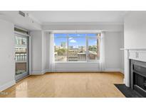 Bright living room features large windows offering city views, a fireplace, and hardwood floors at 510 Glenwood Ave # 510, Raleigh, NC 27603