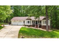 Charming home with a well-manicured lawn, bay windows, and an attached two-car garage at 6204 Silver Spring Ct, Willow Springs, NC 27592