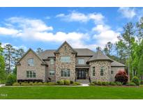 Beautiful two-story stone and brick home with a manicured lawn and inviting double door entrance at 628 Carolina Crossings Dr, Apex, NC 27523