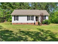 Charming single-story home featuring a well-maintained lawn, classic black shutters, and a welcoming entrance at 7030 Shep Royster Rd, Oxford, NC 27565