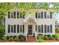 Charming two-story home with black shutters and inviting front entrance, complemented by lush landscaping at 8504 Boot Ct, Raleigh, NC 27615
