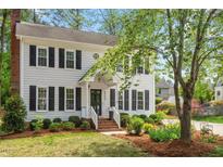 Charming two-story traditional home featuring a well-maintained lawn and lush landscaping at 8504 Boot Ct, Raleigh, NC 27615