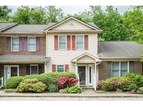 Charming townhome featuring a well-manicured lawn and colorful flowering bushes in front at 942 S Fifth St, Mebane, NC 27302