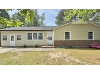 Charming single-story home with yellow siding, a well-maintained lawn, and easy access to the front door at 1011 Wyldewood Rd, Durham, NC 27704