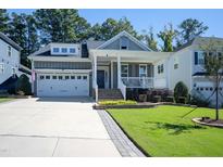 Charming home with a well-manicured lawn, front porch, and two-car garage at 1013 Chelsea Run Ln, Apex, NC 27502