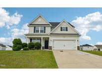 Charming two-story home with a well-manicured lawn and attached two-car garage at 105 Chandon Dr, Princeton, NC 27569