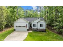 Charming single-Gathering home with a well-manicured lawn and attached two-car garage surrounded by beautiful trees at 118 Chanute Cir, Louisburg, NC 27549