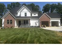 New construction home with white siding, red brick accents, black roof, and an attached two-car garage at 123-125 Ottawa Dr., Louisburg, NC 27549