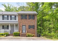 Charming brick townhouse with black shutters and a well-maintained front yard surrounded by lush trees at 1903 Malone Rd # E, Burlington, NC 27215
