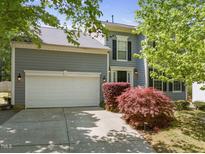 Charming two-story home with a well-manicured lawn, a spacious two-car garage, and elegant architectural details at 1911 Housatonic Ct, Apex, NC 27523