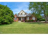 Charming brick home featuring a landscaped front yard, inviting entrance and beautiful curb appeal at 220 Lakecroft Pl, Fuquay Varina, NC 27526