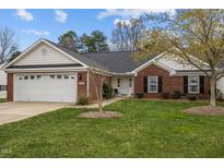 Charming one-story brick home featuring an attached garage and a well-maintained front lawn at 2424 Cambridge Rd, Burlington, NC 27215