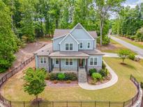 Charming two-story home with a manicured lawn, beautiful landscaping, and a welcoming front porch at 251 Gentry Dr, Pittsboro, NC 27312