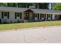 Charming ranch home featuring a well-manicured lawn and welcoming covered front porch at 3725 Fernwood Dr, Raleigh, NC 27612