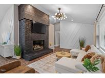Inviting living room showcases a brick fireplace, dark wood accents, and bright, modern decor at 3725 Fernwood Dr, Raleigh, NC 27612