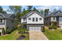 Charming two-story home featuring a two-car garage, stone accents, and a well-maintained front yard at 4009 Reunion Creek Pkwy, Apex, NC 27539