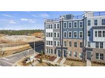 New modern townhomes feature multiple levels, roof decks, and neutral exteriors near a developing neighborhood at 408 Gaston Park Ln # 100, Wake Forest, NC 27587