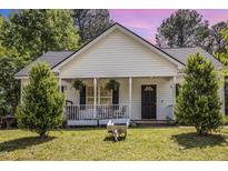 Charming home with a cozy front porch, lush greenery, and well-maintained lawn at 722 E Pine Ave, Wake Forest, NC 27587