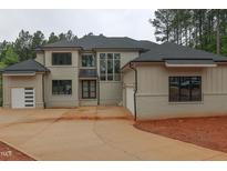 Stunning two-story home featuring brick and siding, an expansive driveway, and multiple garage doors at 7805 Ailesbury Rd, Wake Forest, NC 27587