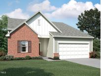 Charming brick and siding home with a two-car garage and well-maintained lawn at 805 Kenyon Spring Dr, Zebulon, NC 27597