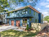 Modern two-story home featuring a three-car garage, blue siding, and a well-manicured lawn at 805 Tower St # 102, Raleigh, NC 27607