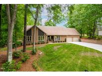 Charming brick home with lush green lawn, mature trees, and a two car garage, offering classic curb appeal at 101 Easton Ct, Garner, NC 27529