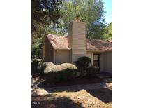 Charming home exterior featuring a brick accent and chimney, nestled among mature trees at 101 Woodbridge Ln, Chapel Hill, NC 27514