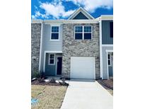 Charming townhome featuring a one car garage and a blend of brick and siding, plus a well-lit driveway at 106 S Chubb Rdg, Wilson's Mills, NC 27520