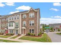 Charming townhouse showcasing a beautifully landscaped front yard and a combination of stone and siding exterior at 1073 Branch Line Ln, Apex, NC 27502