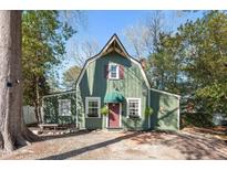 Charming green home featuring a unique roofline, complemented by a brick pathway leading to a quaint front door at 1112 Western Ave, Rocky Mount, NC 27804