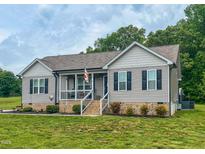 Charming single-story home featuring a covered front porch and manicured lawn at 112 Tillburg Ln, Hurdle Mills, NC 27541