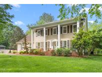 Inviting two-story home showcasing a well-manicured lawn, charming landscaping, and a classic colonial design at 1207 Candlewood Dr, Elon, NC 27244