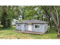 Charming cottage-style home featuring light-blue siding, a welcoming front door, and a wood deck at 1219 Junction Rd, Durham, NC 27704