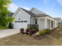 Charming single-story home boasts a two-car garage, manicured landscaping, and inviting covered entry at 140 Azure Mist Dr, Raleigh, NC 27610