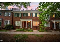 Charming brick townhome with green shutters and manicured front yard landscaping at 1508 W Markham Ave, Durham, NC 27705