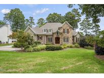 Stunning stone-and-brick home with manicured lawn and mature landscaping at 1605 Hunting Ridge Rd, Raleigh, NC 27615