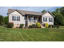 Charming home featuring neutral siding, black shutters, landscaping, and a welcoming porch at 164 Tillburg Ln, Hurdle Mills, NC 27541