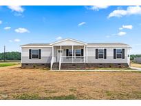Attractive home with black-trimmed windows and a well-maintained lawn, set under a blue sky at 17 Star Dust Ln, Selma, NC 27576