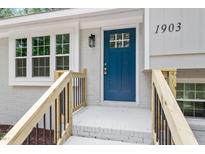 Stylish blue front door with window, leading into the home with freshly painted white trim and an elegant door lamp at 1903 Meadowbrook St, Sanford, NC 27330